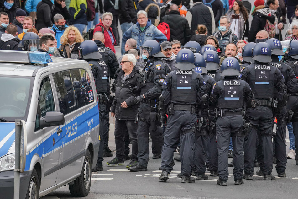 Einsatzkräfte der Polizei führen jeweils einzeln Demonstranten zur Feststellung der Personalien ab, nachdem diese sich nach Ende einer Kundgebung der "Querdenken"-Bewegung entgegen der Auflagen in die Stadt bewegen wollten.
