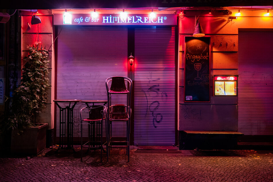 Vor einer Bar im Berliner Stadtteil Friedrichshain sind Stühle übereinander gestapelt. Wegen der Corona-Pandemie gelten eine nächtliche Sperrstunde und strengere Kontaktverbote für drinnen und draußen.
