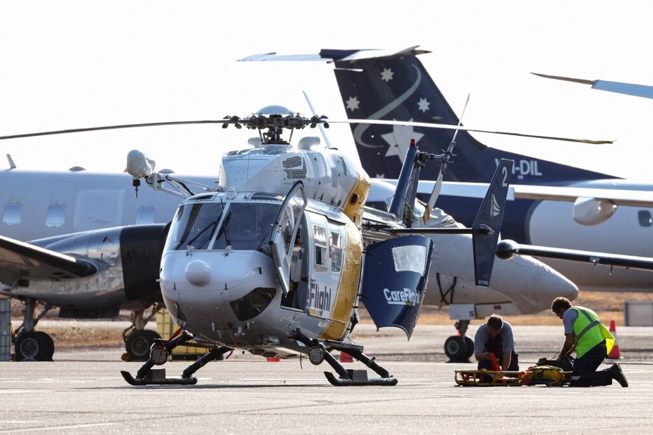 Rescue workers transport those injured in the US Osprey military aircraft crash at a remote island north of Australia's mainland for medical care.