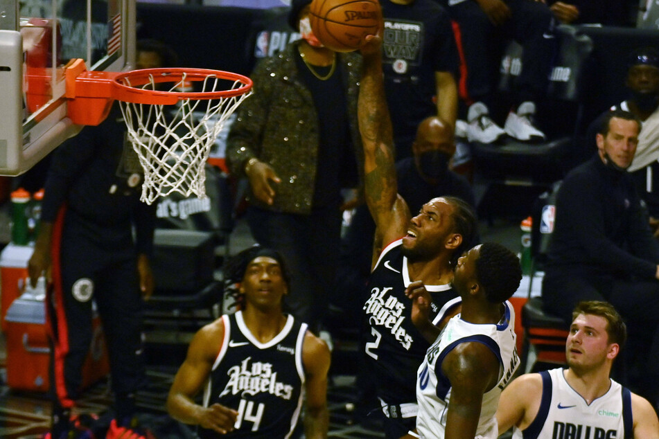 Los Angeles Clippers forward Kawhi Leonard scores on three Dallas Mavericks defenders during the first half of Game 7.
