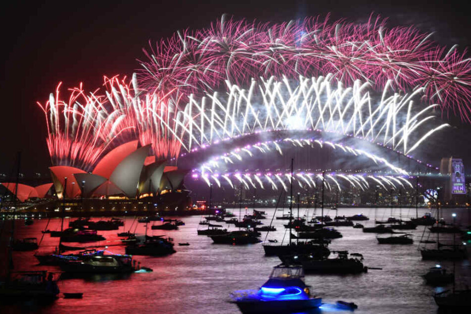 Anlässlich des neuen Jahres explodieren über der Hafenbrücke und dem Opernhaus in Sydney Feuerwerke.