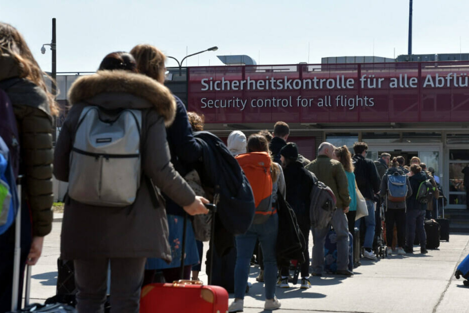 Reisende warten vor der Sicherheitskontrolle.