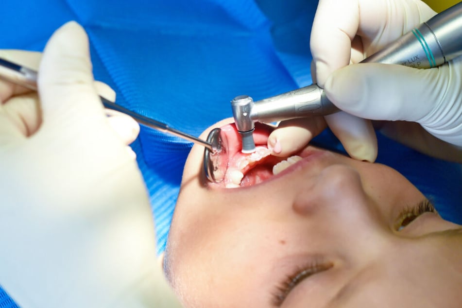 Mund weit auf: Ein Mädchen wird von einer Zahnärztin behandelt, die ihr Handwerk versteht.