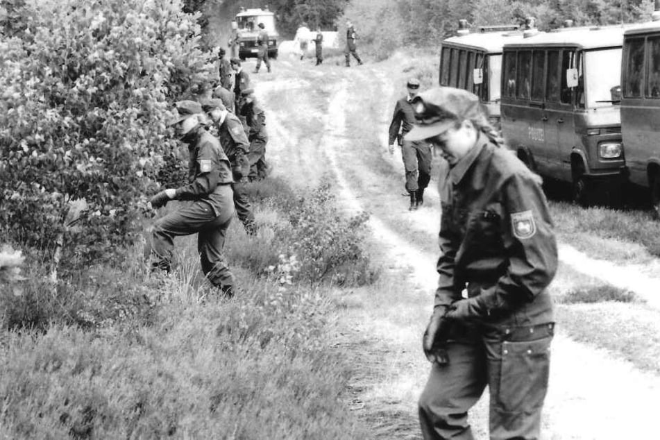 Polizeibeamte durchsuchen im Juli 1989 den Wald in der Göhrde nach einem Doppelmord.
