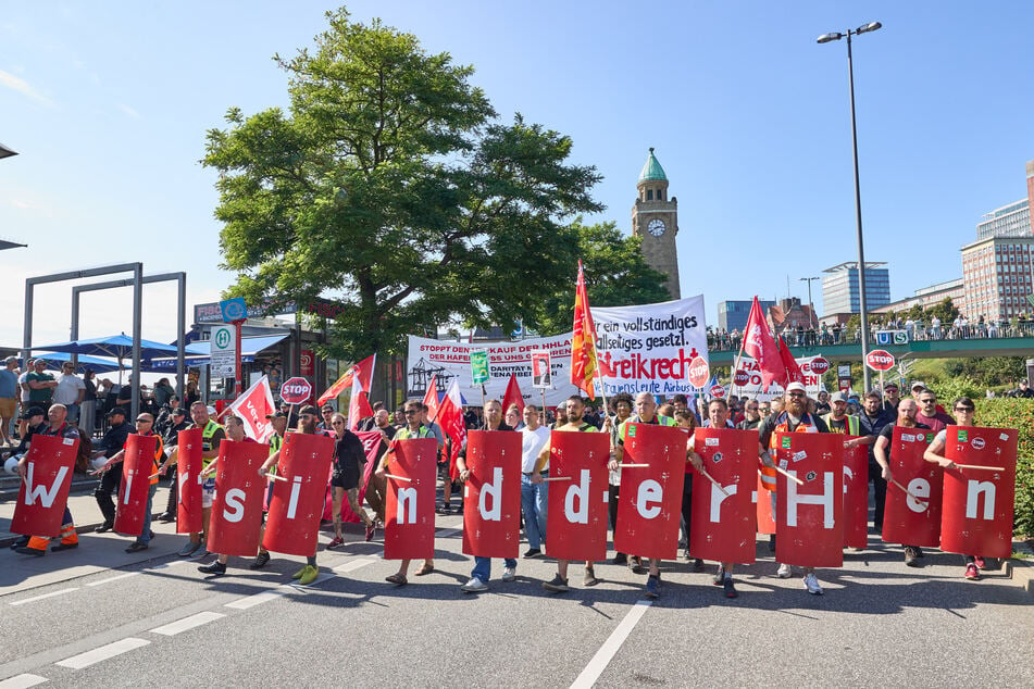 Teilnehmer hielten Schilder, die zusammen den Slogan "Wir sind der Hafen" ergaben.