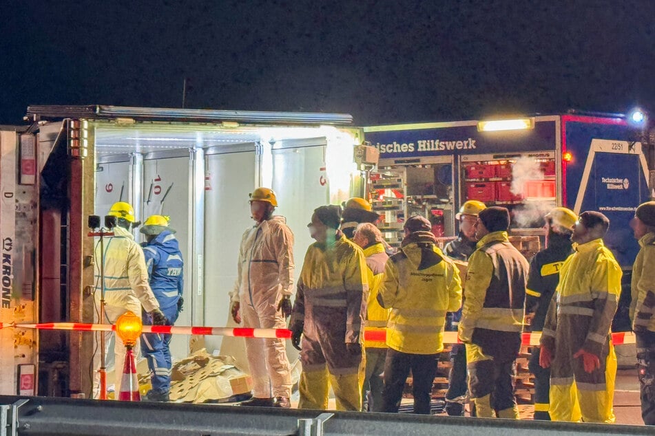 Einsatzkräfte verladen die Kühlprodukte des kaputten Lkws.