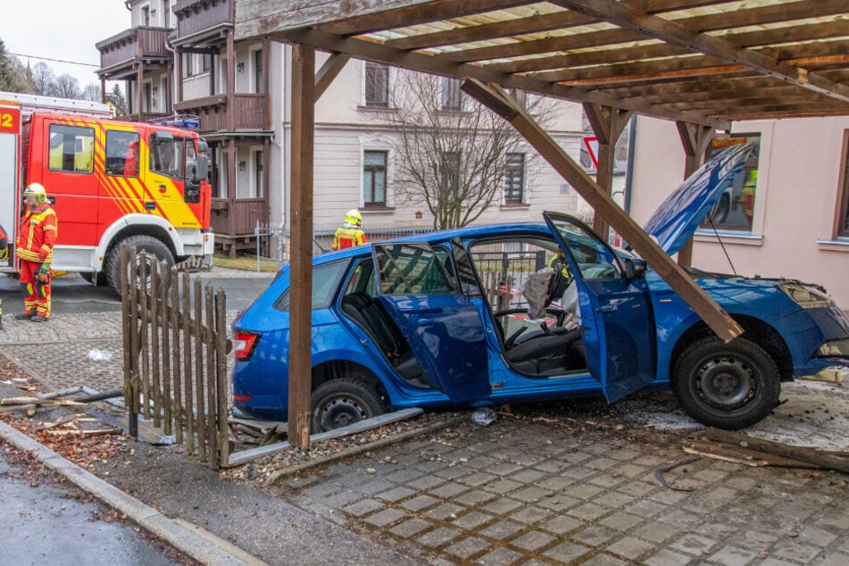 Škoda kommt von Straße ab und kracht in Carport, Fahrerin in Auto eingeklemmt