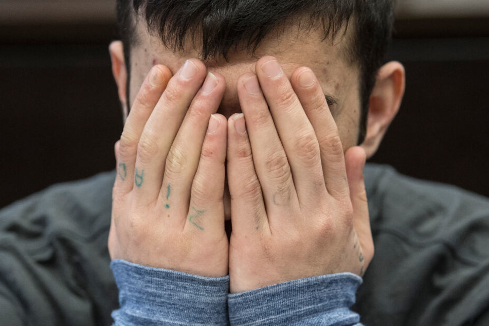 Der Angeklagte Ali B. hält sich während des Prozesses die Hände vor das Gesicht.