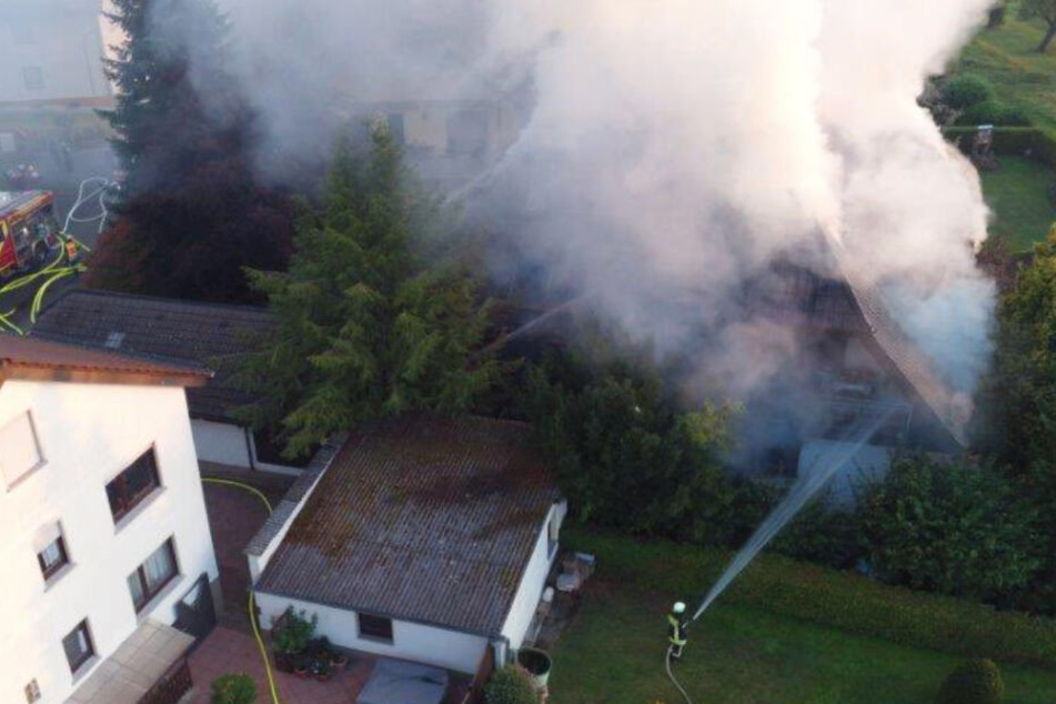 Das Bild zeigt links das qualmende Einfamilienhaus in Gießen-Lützellinden.
