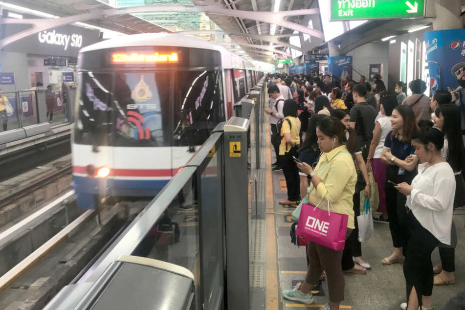 Hohe Glasscheiben an einem Bahnsteig in Bangkok (Thailand) des Bahnhofs Salah Daeng sorgen dafür, dass Passagiere bei der Einfahrt eines Nahverkehrszuges nicht auf die Gleise fallen oder gestoßen werden können.