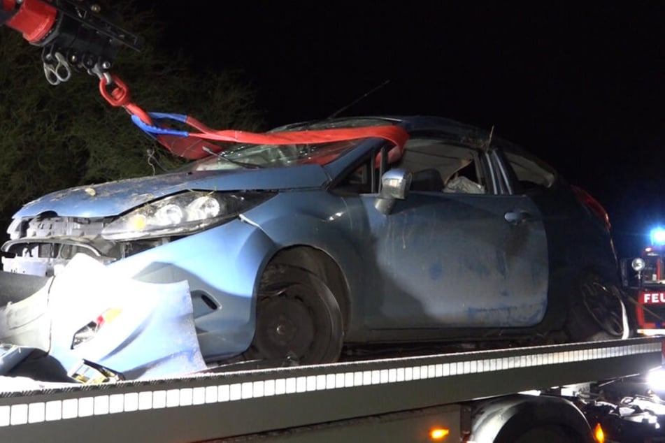 Das Autowrack wird auf ein Abschleppfahrzeug verladen.