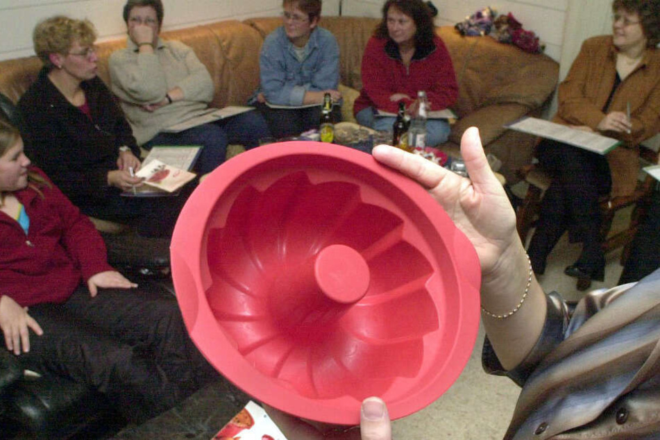 Eine rote Kuchenbackform wird von einer Verkäuferin bei einer "Party" im Wohnzimmer angepriesen. (Archivfoto)