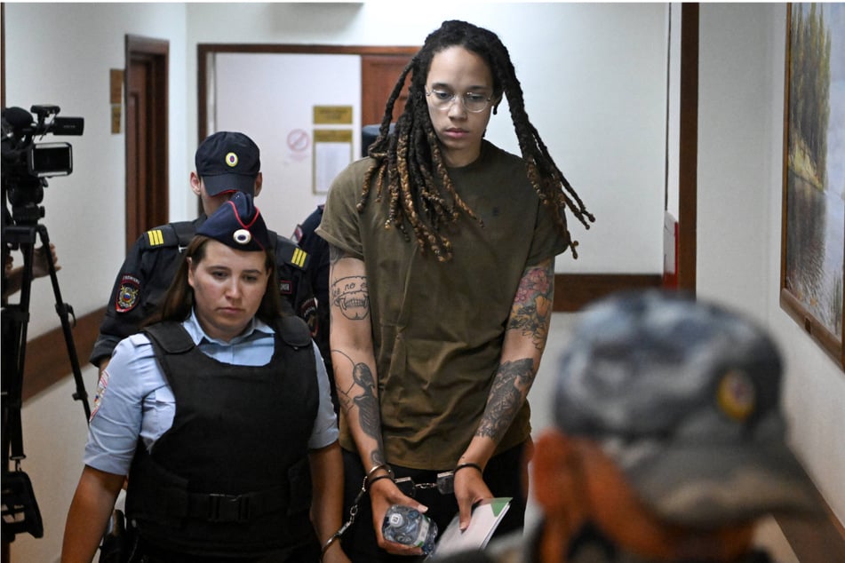 Brittney Griner (c.) being escorted by police before a hearing during her trial on charges of drug smuggling, in Khimki, outside Moscow on Tuesday.