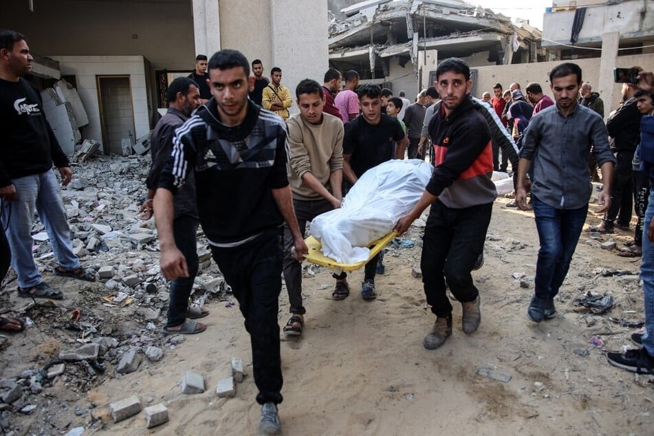 Palestinians carry the body of a victim killed in Israeli strikes toward a cemetery in Jabalia in the northern Gaza Strip on November 10, 2024.