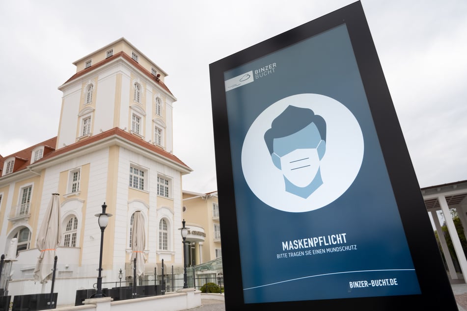 Ein Schild zur Maskenpflicht steht auf der Strandpromenade im Ostseebad auf Rügen.