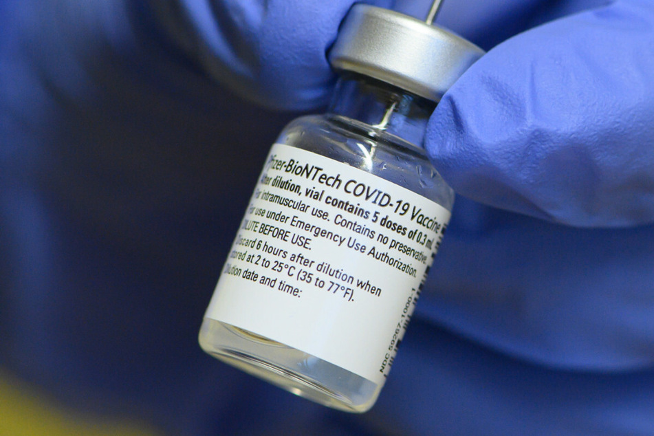 Eine Mitarbeiterin des Städtischen Klinikum Dresden hält im Impfzentrum ein Injektionsfläschchen mit dem Corona-Impfstoff von Biontech/Pfizer in den Händen. (Symbolbild)