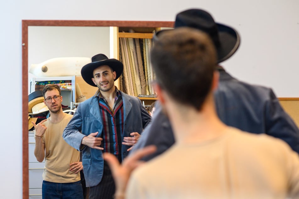 Der Kostüm- und Bühnenbildner Lukas Pirmin Wassmann (r.) probiert in der Anprobe vom Theater Magdeburg mit dem Balletttänzer Giacomo Quatraccioni ein Kostüm zum Musical "Oklahoma!" an.