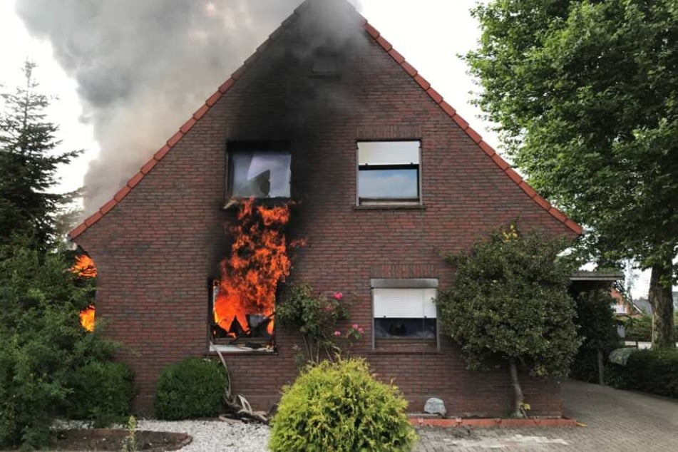 Flammen schlagen aus dem Zweifamilienhaus.