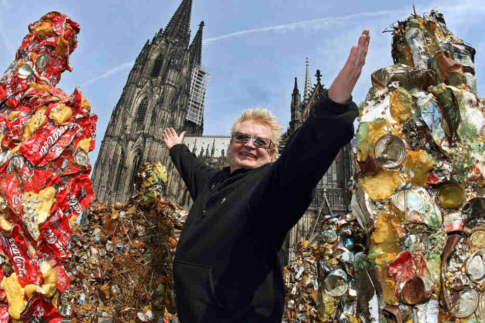 HA Schult posiert im April 2014 mit einigen seiner Müllmenschen vor dem Kölner Dom.