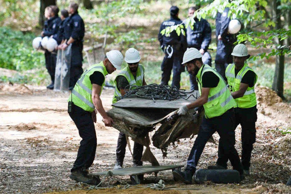 RWE-Mitarbeiter und die Polizei bei der Bergung des Autos im Hambacher Forst.