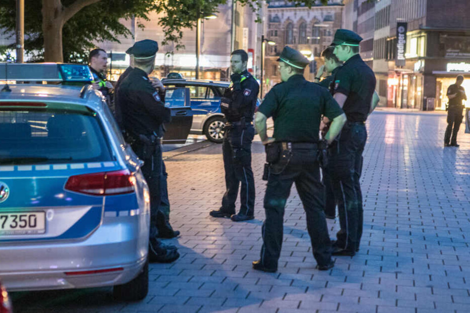 Polizisten stehen am Einsatzort in der Hamburger Innenstadt.