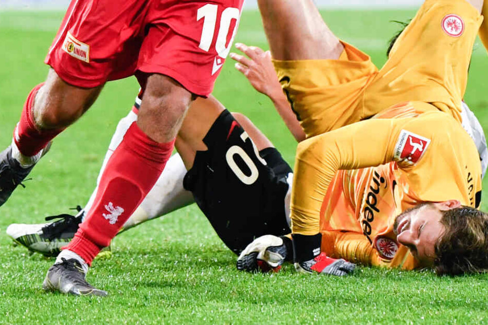Torhüter Kevin Trapp (r) und Makoto Hasebe (hinten) von Eintracht Frankfurt sowie Sebastian Andersson von Union Berlin prallen in einem Zweikampf aufeinander.