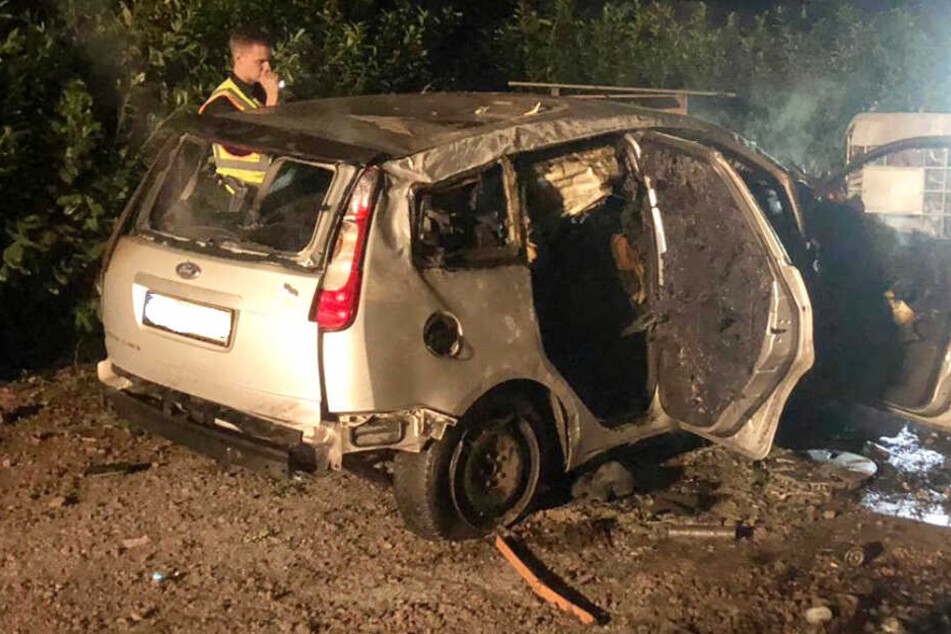 Ein Polizist sieht sich das ausgebrannte Wrack an, in dem ein 30-Jähriger starb.