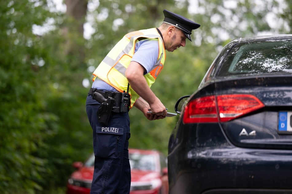 Ein Polizist spricht bei einer Kontrolle mit einem Autofahrer. (Archivfoto)