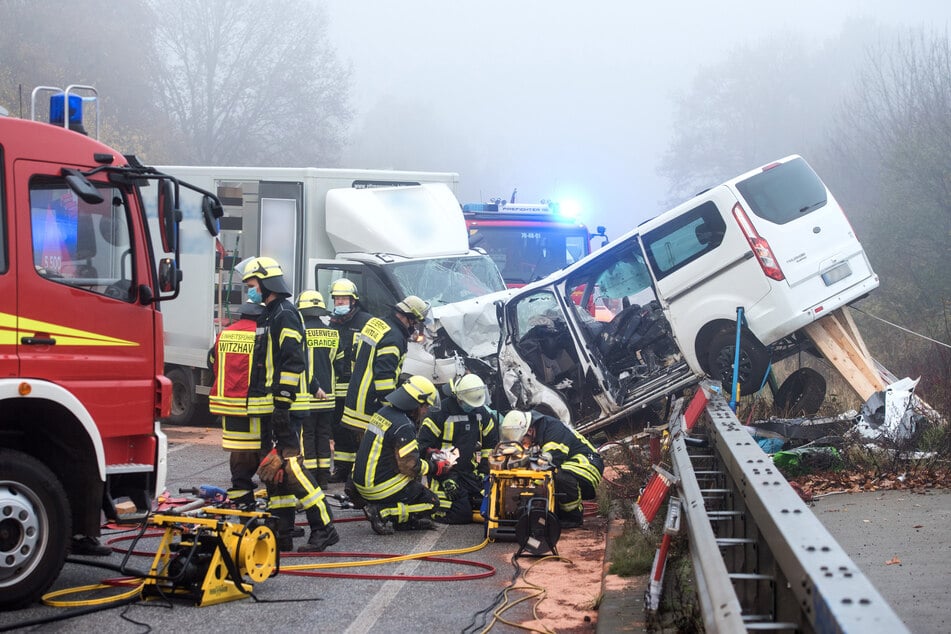 Einsatzkräfte der Feuerwehr arbeiten auf der Bundesstraße 404 zwischen den Orten Grande und Trittau an der Unfallstelle.