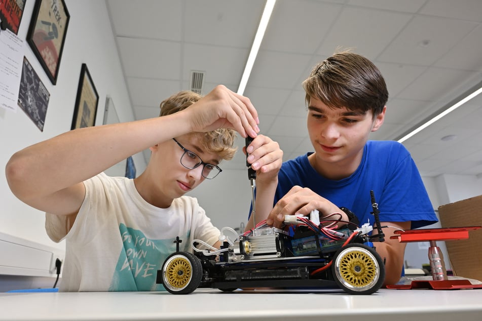 Fynn (15, l.) und Konrad (16) schrauben am Wasserstoff-Modell-Auto.
