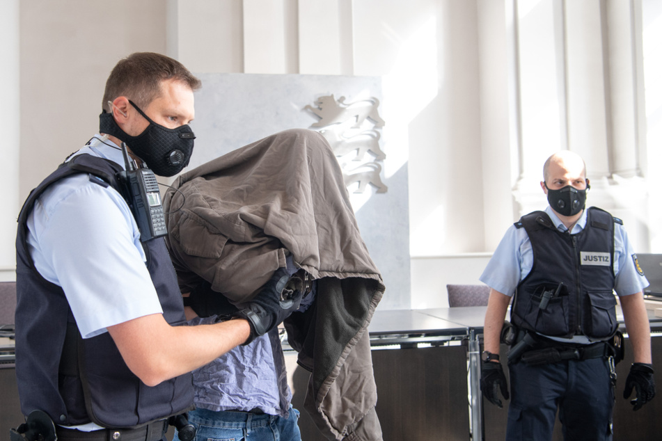 Der Angeklagte versteckte sich am Eröffnungstag unter einer Jacke.