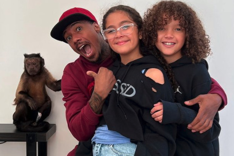 Nick Cannon (l) poses with his twins whom he shares with his ex-wife Mariah Carey.