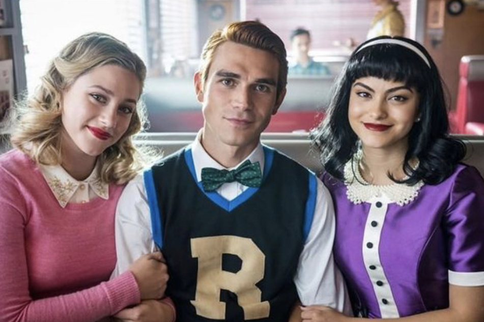 From l to r: Lili Reinhart, KJ Apa, and Camila Mendes star as Betty Cooper, Archie Andrews, and Veronica Lodge in the CW series, Riverdale.