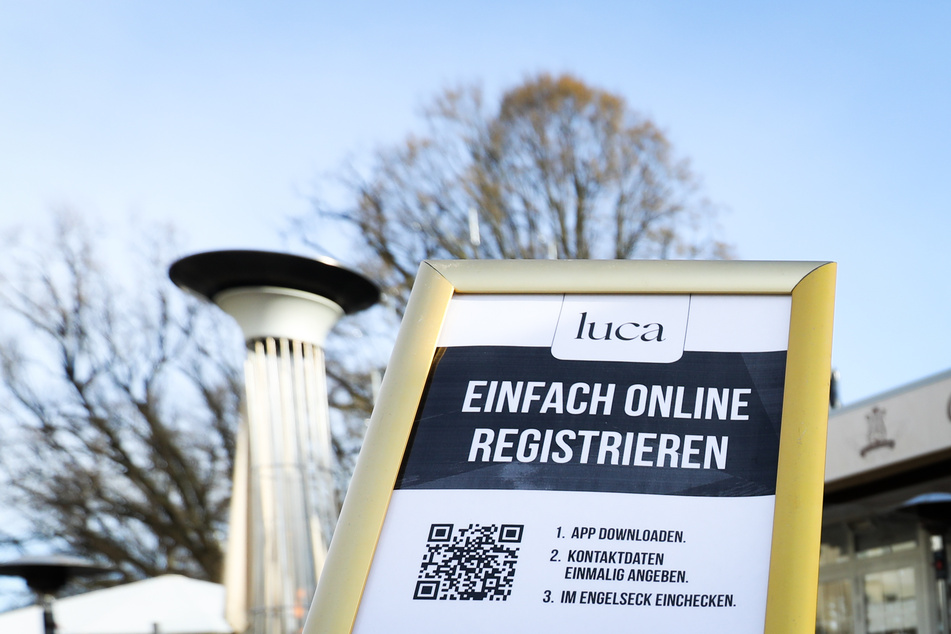 Ein Hinweisschild zur Nutzung der Luca-App ist am Eingang zu einem Cafe zu sehen. So können sich Gäste registrieren.
