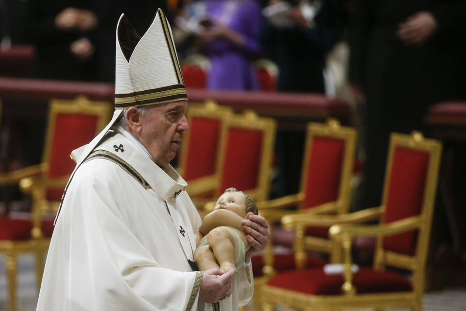 Pope Francis held a figurine of baby Jesus during the Christmas Holy Mass in Saint Peter's Basilica at the Vatican on Friday night.
