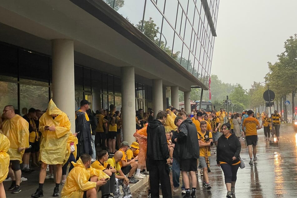 Dynamo-Fans suchen im Eingangsbereich des Rudolf-Harbig-Stadion Schutz vor dem Regen.