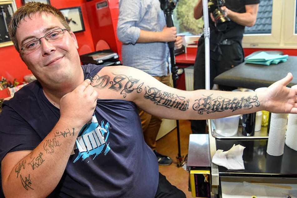 Auf dem linken Arm prangt das Tattoo seines Lieblingsvereins, rechts die Unterschriften der Spieler.