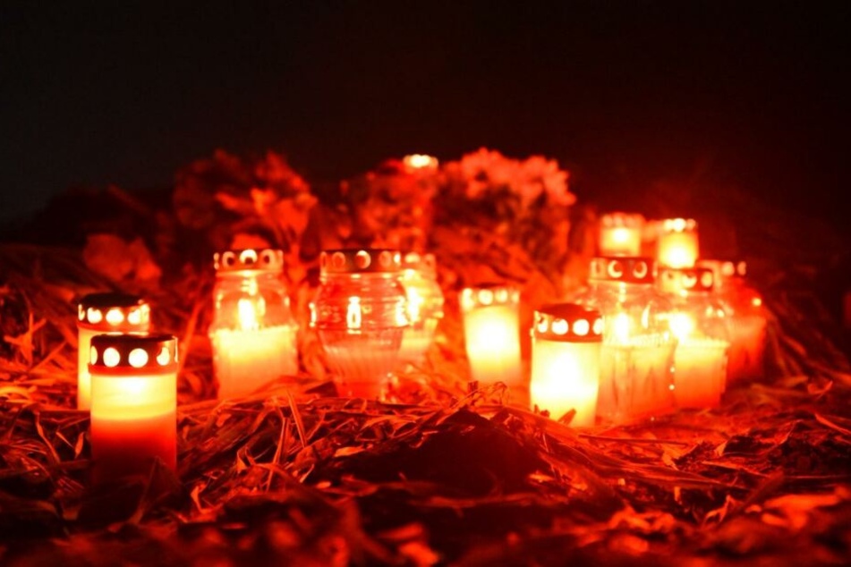 Trauernde haben Kerzen und Blumen für den jungen Mann an der Unfallstelle niedergelegt.