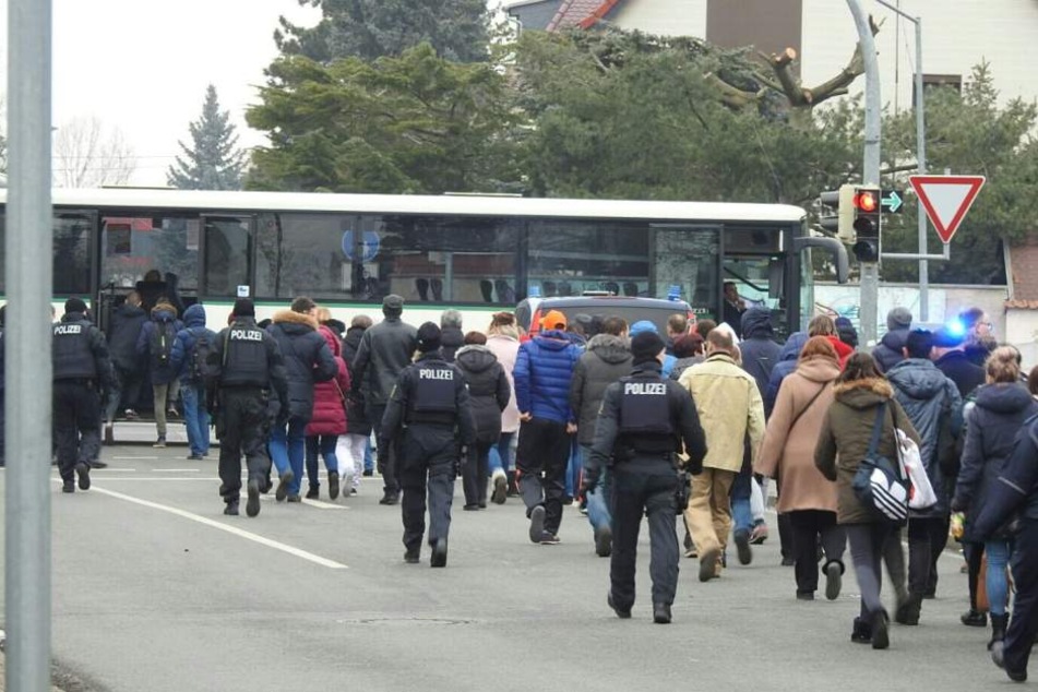 Die Schüler werden unter Begleitung der Polizei zu den Bussen gebracht, die sie in eine Grundschule fahren.