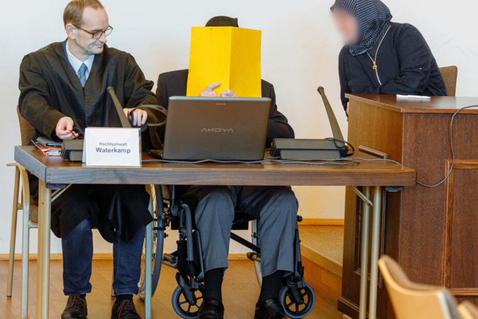 Der Angeklagte sitzt vor Beginn des Prozesses zwischen seinem Anwalt Stefan Waterkamp (links) und einer Begleiterin im Gerichtssaal.