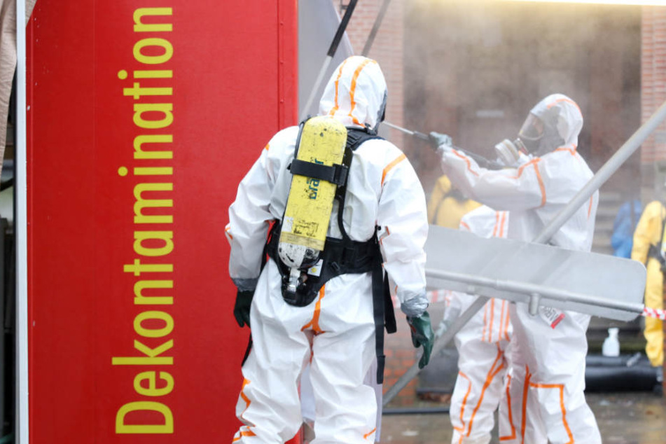 Einsatzkräfte der Feuerwehr Hamburg werden vor dem Amtsgericht Harburg desinfiziert.