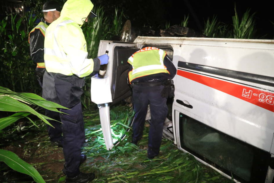 Die Polizisten untersuchen den Unfallwagen.