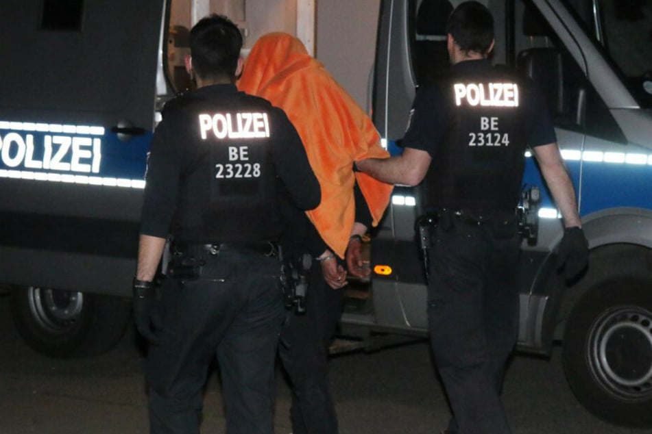 Polizisten führen einen der Einbrecher ab.