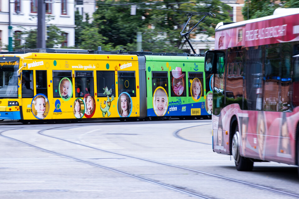 Eine Straßenbahn sowie ein Linienbus des Nahverkehrs Schwerin (NVS) sind in der Innenstadt unterwegs.