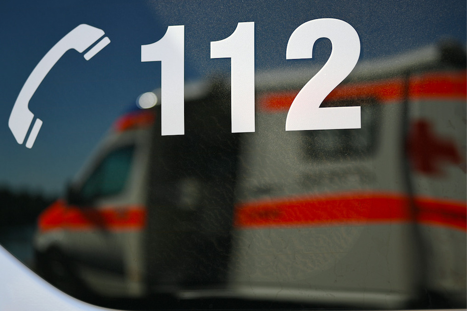 Ein Rettungswagen spiegelt sich in einem Fenster eines anderen Rettungswagen mit der Aufschrift "112". Die Notrufnummern sind in München derzeit gestört. (Symbolbild)