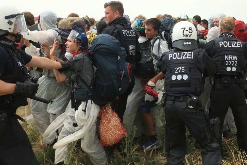 Polizisten versuchen, Aktivisten am Betreten des Tagebau Garzweiler zu hindern.