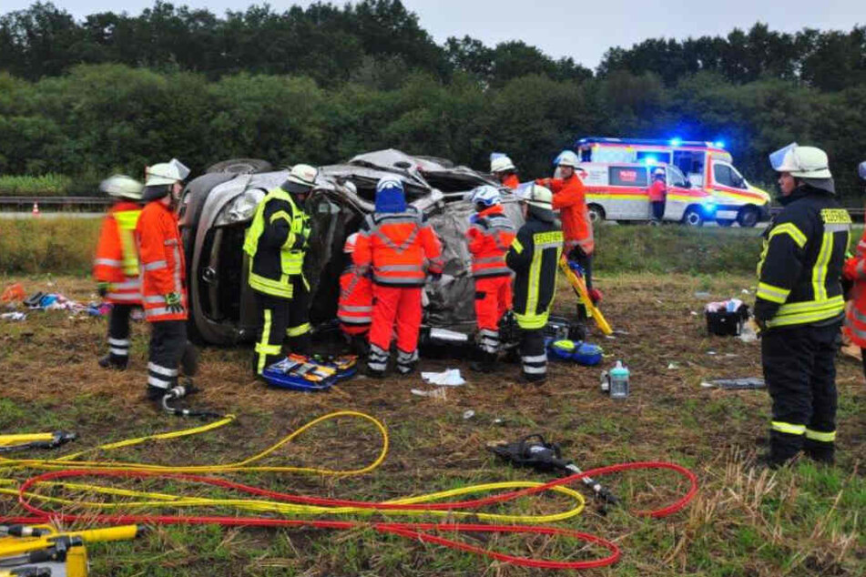 Einsatzkräfte der Feuerwehr befreien die Unfallopfer aus dem Autowrack.