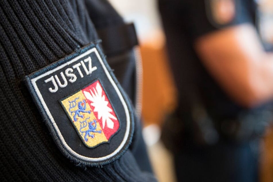 Justizbeamte stehen im Gerichtssaal.