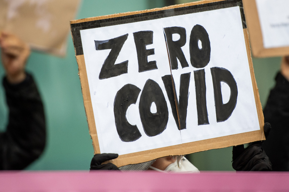 Ein Teilnehmer einer Demonstration hält ein Schild mit "Zero Covid". In Weiden könnte die Inzidenz bald auf Null sinken. (Symbolbild)
