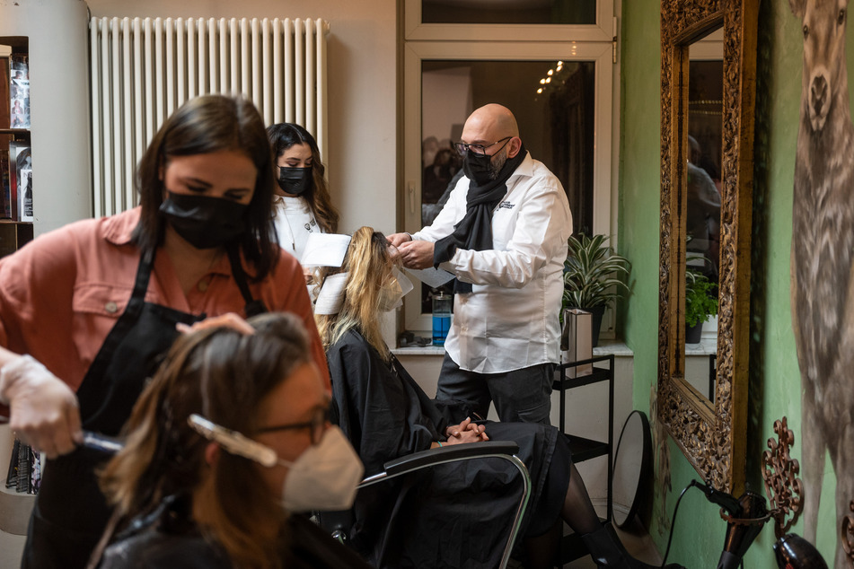 Der Dortmunder Friseur Marco Trapani und zwei seiner Angestellten schneiden kurz nach Mitternacht zwei Kundinnen die Haare.